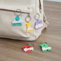 Colourful personalised initial and name keyrings styled with a neutral canvas backpack